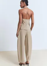 Pantalón de tiro medio color beige con diseño balloon y pinzas en la parte delantera. Cuenta con bolsillos laterales y cierre oculto.