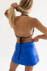 Minifalda azul eléctrico asimétrica con cierre de botones y bolsillo con cremallera.