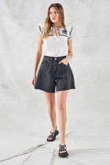 Blusa de color blanco con detalles bordados en negro, cuello redondo con cordones ajustables y mangas cortas con volados.