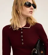 Vestido corto de punto color borgoña, con cuello polo blanco abotonado y mangas largas.