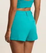 Short pollera corto de bengalina color turquesa, con trabillas en la cintura, diseño cruzado y bajo asimétrico.