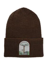 Gorro tipo beanie de punto grueso color marrón chocolate, con vuelta y parche frontal bordado con diseño de un árbol baobab y texto alusivo.