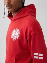 Canguro rojo con capucha, bolsillo frontal tipo canguro y estampado circular blanco en el pecho con temática de la Copa Mundial de 1966.