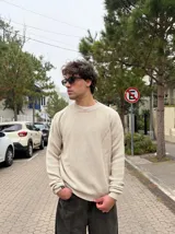 Sweater de tejido de punto en color beige, con cuello redondo y diseño de corte regular.