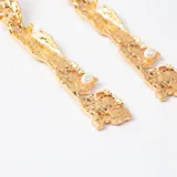 Caravanas colgantes de diseño orgánico con textura irregular en acabado dorado, con una pequeña perla incrustada en la parte inferior.