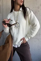 Sweater de punto color natural con diseño de flores bordadas en relieve, cuello redondo y puños acanalados. Presenta un corte clásico y versátil.