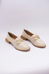 Mocasines de cuero en tono bronce metalizado, con detalle de aplique metálico dorado en el empeine y taco cuadrado bajo de madera.