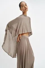 Top capa asimétrico de color marrón, confeccionado en hilatura con mezcla de viscosa, con cuello redondo y mangas amplias tipo capa.