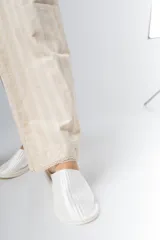 Pantalón de algodón color crudo con rayas verticales finas en beige, corte recto, cintura con elástico y detalle de puntilla en cintura y ruedo.