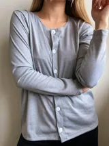 Saco gris de manga larga con botones blancos al frente.