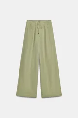 Pantalón ancho de tiro alto color verde claro, con cintura elástica ajustable con lazo del mismo tejido y pinzas delanteras.