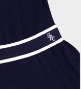 Vestido corto azul marino de corte regular con falda plisada. Presenta ribetes de rayas blancas en contraste en el escote, las sisas y la cinturilla elástica.