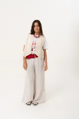 Remera blanca de algodón y poliéster con cuello redondo y estampado de mujeres tomando vino y la frase "Wine Not?".