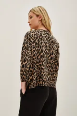 Sweater de punto con estampado de leopardo en tonos marrón y negro, de manga larga y cuello redondo. Presenta detalles de lentejuelas negras aplicadas sobre el tejido. Confeccionado en una mezcla de poliamida, acrílico, cachemira y seda.