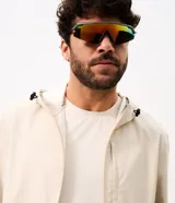 Campera deportiva masculina Get Over con capucha ajustable, cierre frontal completo, bolsillos laterales y recortes horizontales, confeccionada en poliéster tecnológico de color beige.