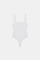 Body de tejido elástico blanco con estampado de lunares negros, escote cuadrado y tirantes anchos.