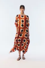 Kaftan maxi amplio de color amarillo, con escote redondo, mangas cortas y ruedo irregular. Presenta un diseño estampado a cuadros con efecto teñido.