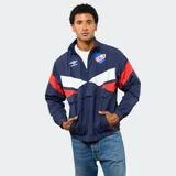 Buzo de nylon con medio cierre, diseño deportivo con bloques de color azul, blanco y rojo. Presenta el escudo del Club Nacional de Football y el logo de Umbro en el frente.