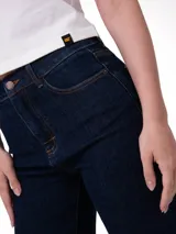 Pantalón de jean color azul índigo oscuro, de corte recto y tiro alto, con costuras en contraste y cierre frontal con botón y cremallera.