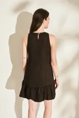 Vestido corto de lino color bordó, sin mangas, con escote redondo, costuras decorativas con flecos y falda estilo globo con volados en el ruedo.
