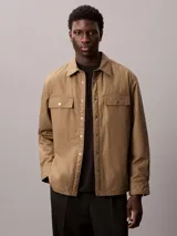 Sobrecamisa de algodón Calvin Klein con relleno ligero, diseño de corte regular, cierre frontal con botones a presión, bolsillos frontales con solapa y puños abotonados.