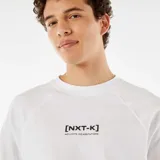 Camiseta blanca de manga corta raglán con estampado central con texto enmarcado.