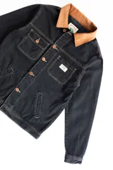 Campera corta de jean negro con cuello de pana marrón, confeccionada en jean grueso 100% algodón de 14 onzas, con costuras marrones en contraste.