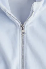 Campera corta de velour color celeste claro, con cuello elevado, cierre frontal y bolsillos insertados. Presenta elástico fruncido en puños y bajo.