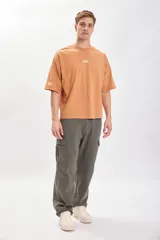Camiseta color naranja con estampado de motivos relacionados al café, corte amplio y recto.