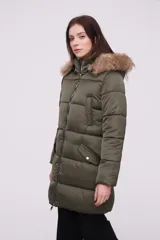 Campera puffer de color verde militar, con cierre frontal, bolsillos laterales y capucha con borde de piel sintética.
