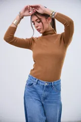 Polera de punto acanalado color dulce de leche, con cuello alto y mangas largas.