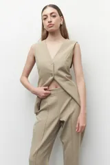 Pantalón de vestir color beige, de corte recto, con costuras verticales en el frente y cierre lateral invisible.