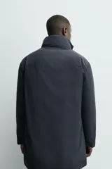 Parka acolchada impermeable color gris oscuro, de corte regular fit, con cuello doble subido, bolsillos de vivo en la cadera y cierre frontal con cremallera oculta por solapa con botones a presión.