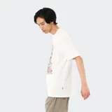 Remera blanca de algodón con estampado de personas y el logo de New Balance.