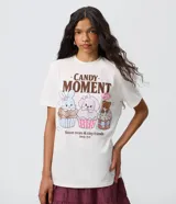 Remera de algodón color blanco de corte regular, con cuello redondo y mangas cortas. Presenta un estampado frontal multicolor con animales sobre cupcakes y el texto "Candy Moment".