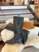 Botas altas de montar de cuero color marrón, con diseño plano y suela de goma.