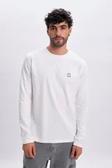 Remera manga larga blanca con cuello redondo y pequeño bordado circular con la frase "Good Ways" en el pecho.