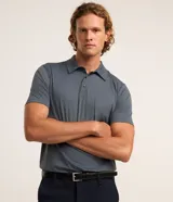 Camisa polo masculina de manga corta, confeccionada en tejido técnico de poliamida con elastano. Presenta cuello inglés con cierre de botones y diseño liso en color marrón, con tecnología de secado rápido y confort térmico.