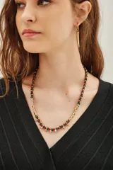 Collar corto con cuentas de metal dorado y cuentas de vidrio azul oscuro, con detalles de pequeñas borlas doradas en la parte frontal.