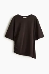 Remera marrón de punto suave de algodón, con cuello redondo, mangas cortas amplias y diseño asimétrico con frunce lateral.