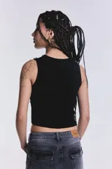 Musculosa negra con cuello redondo y detalle de strass y tachas plateadas en el frente y los bordes.