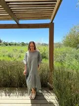 Vestido verde oliva de lino, corte suelto, con mangas abullonadas y volado en el ruedo.