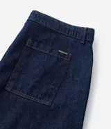 Bermuda tipo jorts de corte amplio y tiro medio, confeccionada en denim de algodón azul oscuro. Presenta diseño de cinco bolsillos, cierre frontal con botón y costuras en tono contrastante.