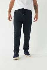 Pantalón de jogging azul marino con puños ajustados, cintura elástica con cordón ajustable y logo estampado en la pierna.