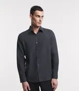 Camisa de manga larga confeccionada en tricolina de algodón, con cuello inglés, cierre frontal de botones y puños abotonados. Diseño liso y versátil.