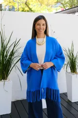 Saco abierto de punto color azul vibrante, con mangas tres cuartos y detalle de flecos largos en el ruedo.