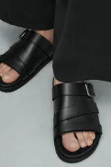 Sandalia monocolor negra con tiras cruzadas en el empeine, detalle de hebilla metálica rectangular y plantilla con horma anatómica.