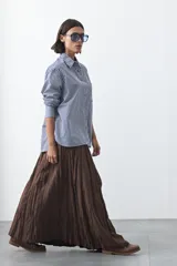 Falda larga de silueta amplia y caída fluida, con cintura elástica y textura arrugada.