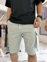 Bermuda cargo de jean color gris claro, con bolsillos laterales con solapa y corte oversize.