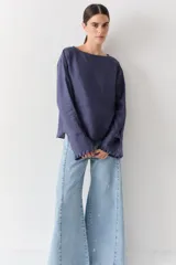 Blusa de lino color azul marino, con cuello bote, mangas largas y puños con volados y detalle de botones.